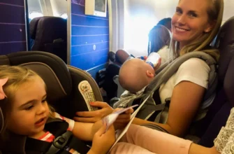 Flying with a baby-Mom wearing baby in Ergo carrier on a plane